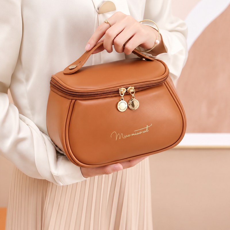 Trousse de toilette femme PU camel portée à la main